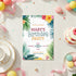 A tropical-themed birthday party invitation card is displayed in a beautifully styled flat-lay scene with pastel balloons, a cup and saucer, a slice of cake, macarons, and confetti on a white wooden table.