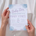 Baby shower invitation held by hands with a light background
