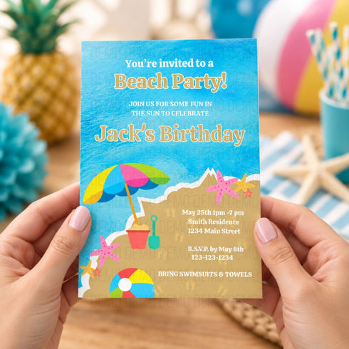 A person holds a beach-themed birthday invitation card in front of a blurred beach party background. The card features a blue watercolor sky, sandy beach, colorful beach umbrella, starfish, and a beach ball, with text reading 'You're invited to a Beach Party! Jack's Birthday' and event details.