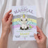 Invitation card with a unicorn design held by hands against a white background