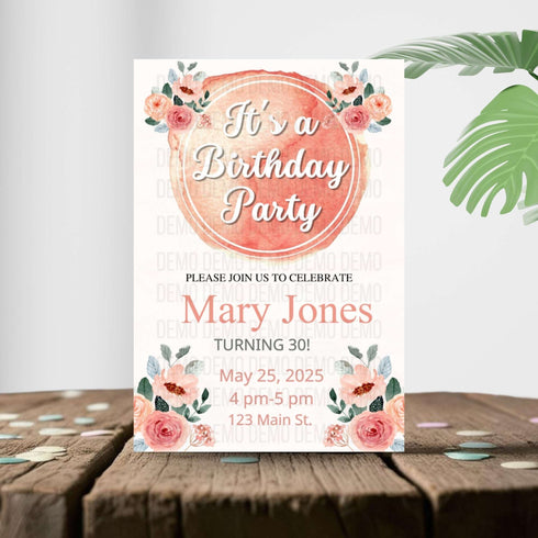 Birthday party invitation with floral design on a wooden surface