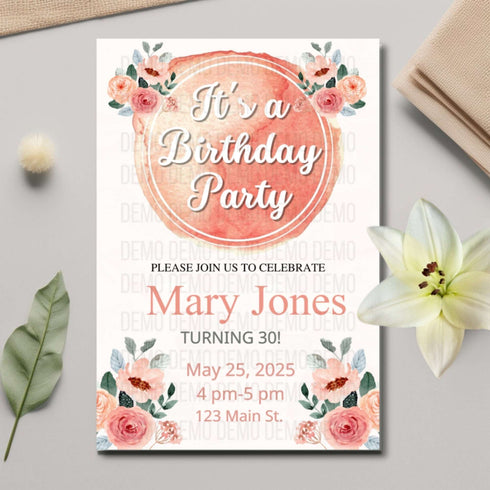 Birthday party invitation with floral design on a gray surface with flowers and leaves.