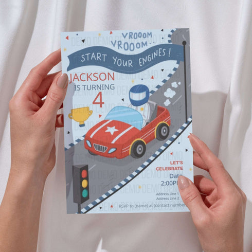 Person holding a birthday party invitation with a car and racing theme.