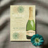 New Year's Eve party invitation with champagne bottle design on a textured surface with a flower.