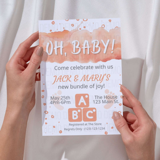 Baby shower invitation held by hands with a light background
