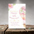 Birthday party invitation with pink hot air balloon and flowers on a wooden surface.