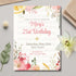 Floral birthday invitation card on a light gray surface with decorative elements.