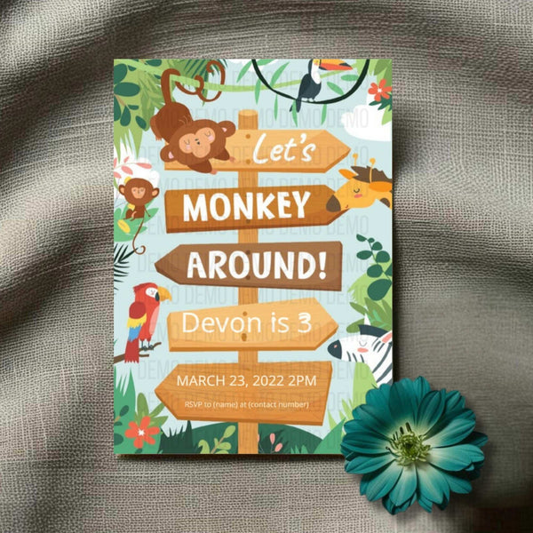 Invitation card with monkey theme on a textured surface with a flower.
