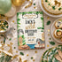 A styled flat-lay of a safari-themed birthday party invitation card reading 'Jack's Wild Birthday Bash,' surrounded by matching party decor including plates, cupcakes, balloons, confetti, and animal-shaped accessories on a beige fabric background.