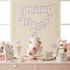 Birthday cake with floral decorations and 'Happy Birthday' banner on a table.