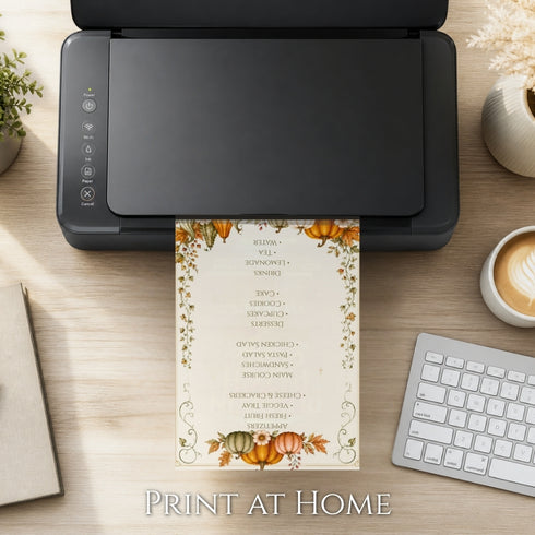 A black printer sits on a light wood desk with a printed fall-themed wedding guest list or menu card emerging from the bottom. The card has orange pumpkins, green leaves, and elegant black text on a cream background.
