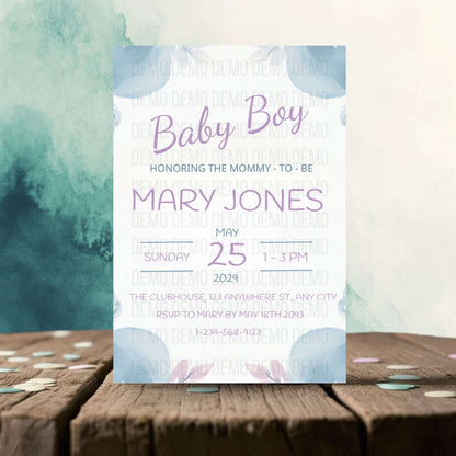 Baby shower invitation card for a baby boy on a wooden surface with watercolor design