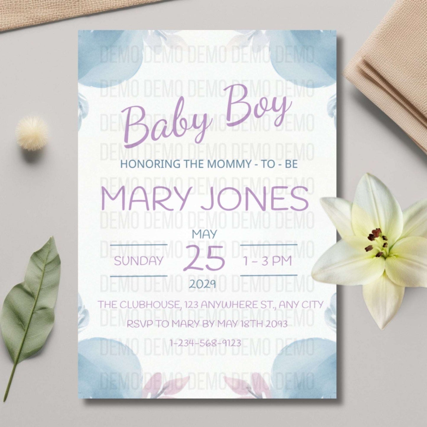 Baby shower invitation for a baby boy with floral design on a light surface.