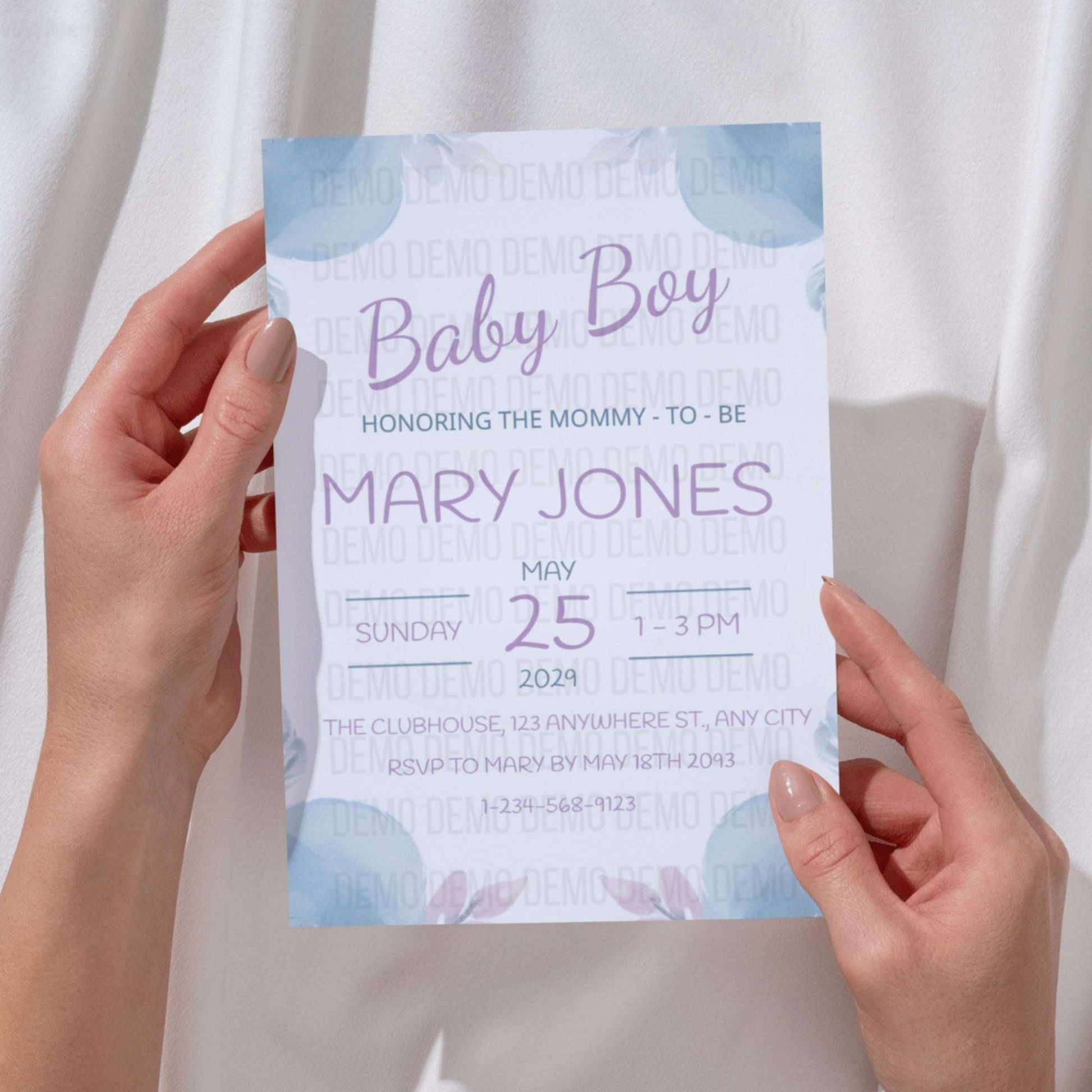 Baby shower invitation held by hands with a light background