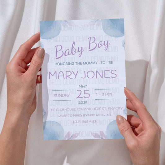Baby shower invitation held by hands with a light background