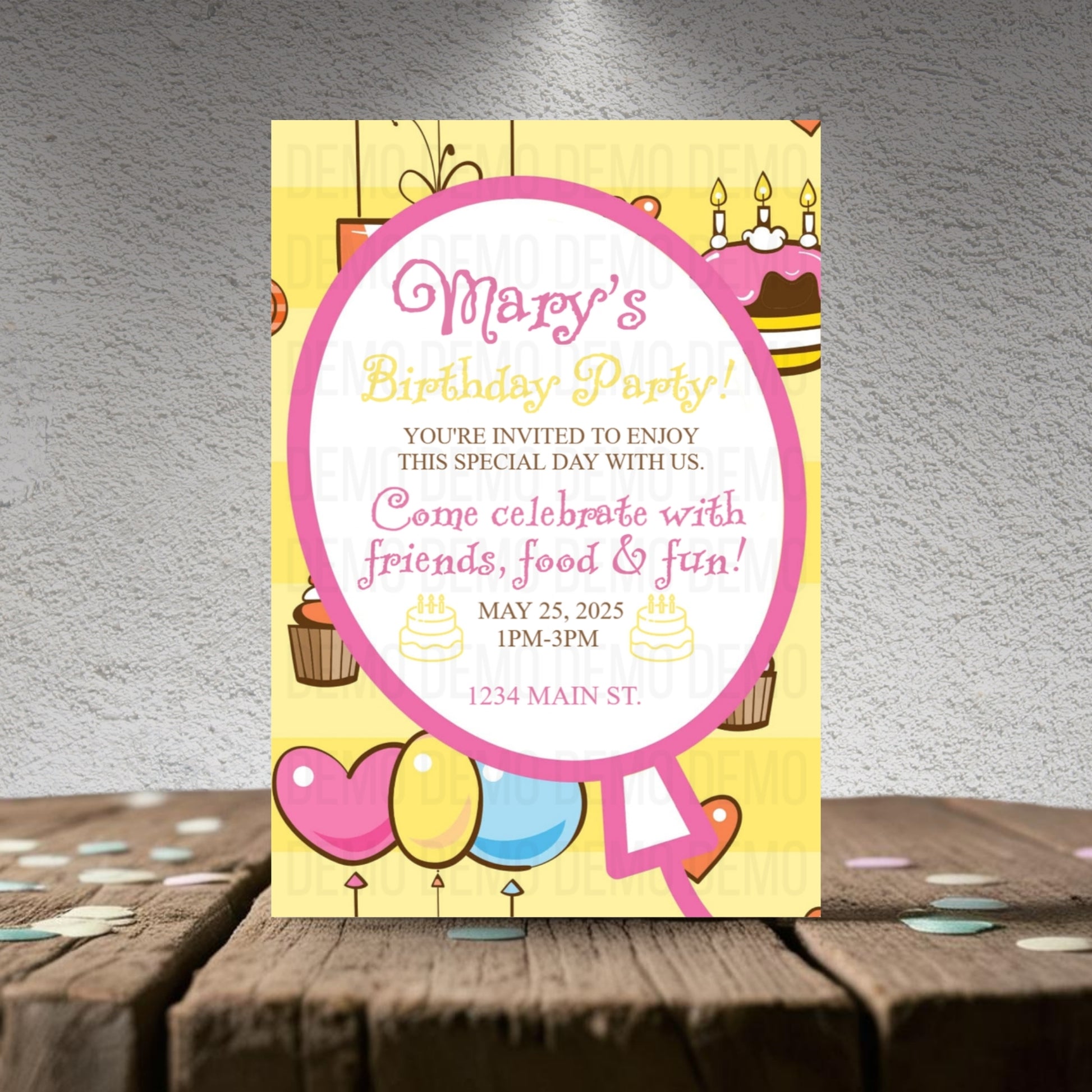 Birthday party invitation card with colorful design on a wooden surface