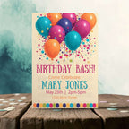Birthday bash invitation with colorful balloons on a wooden surface