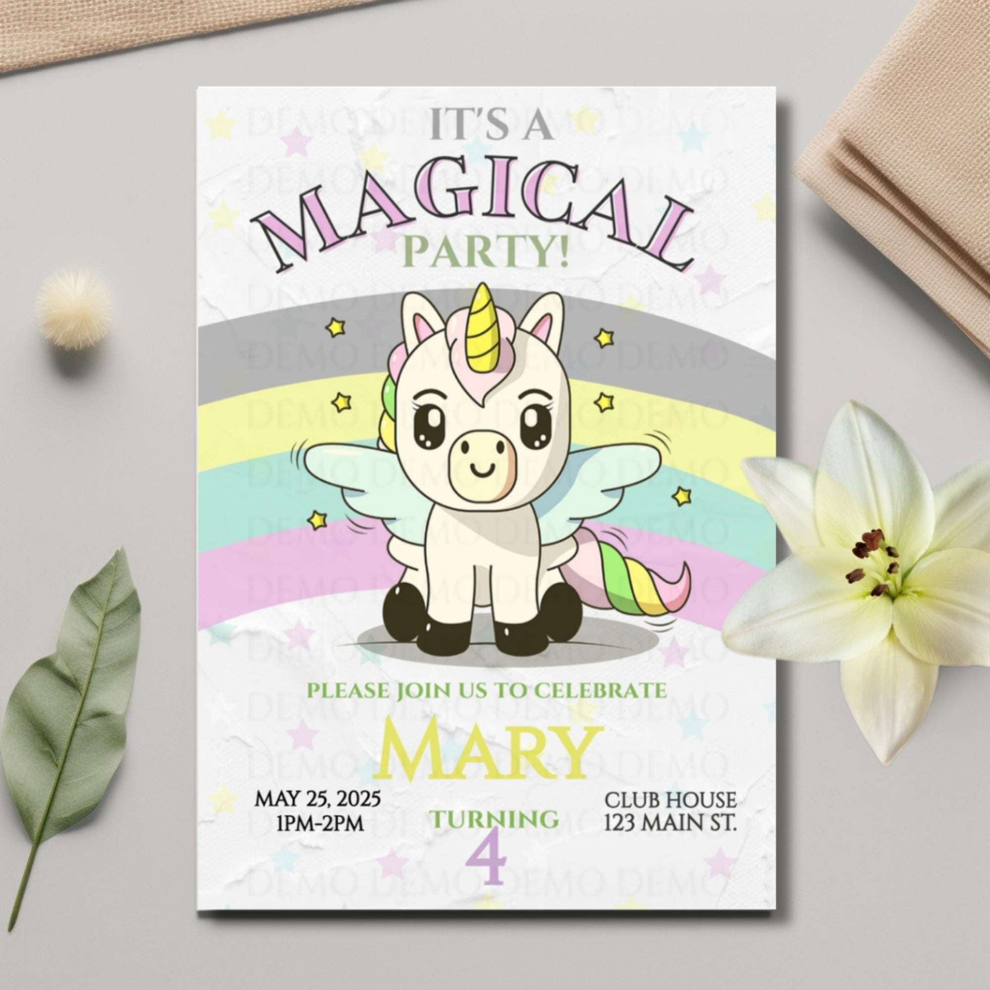 Invitation card with a unicorn design on a light gray surface with decorative elements.