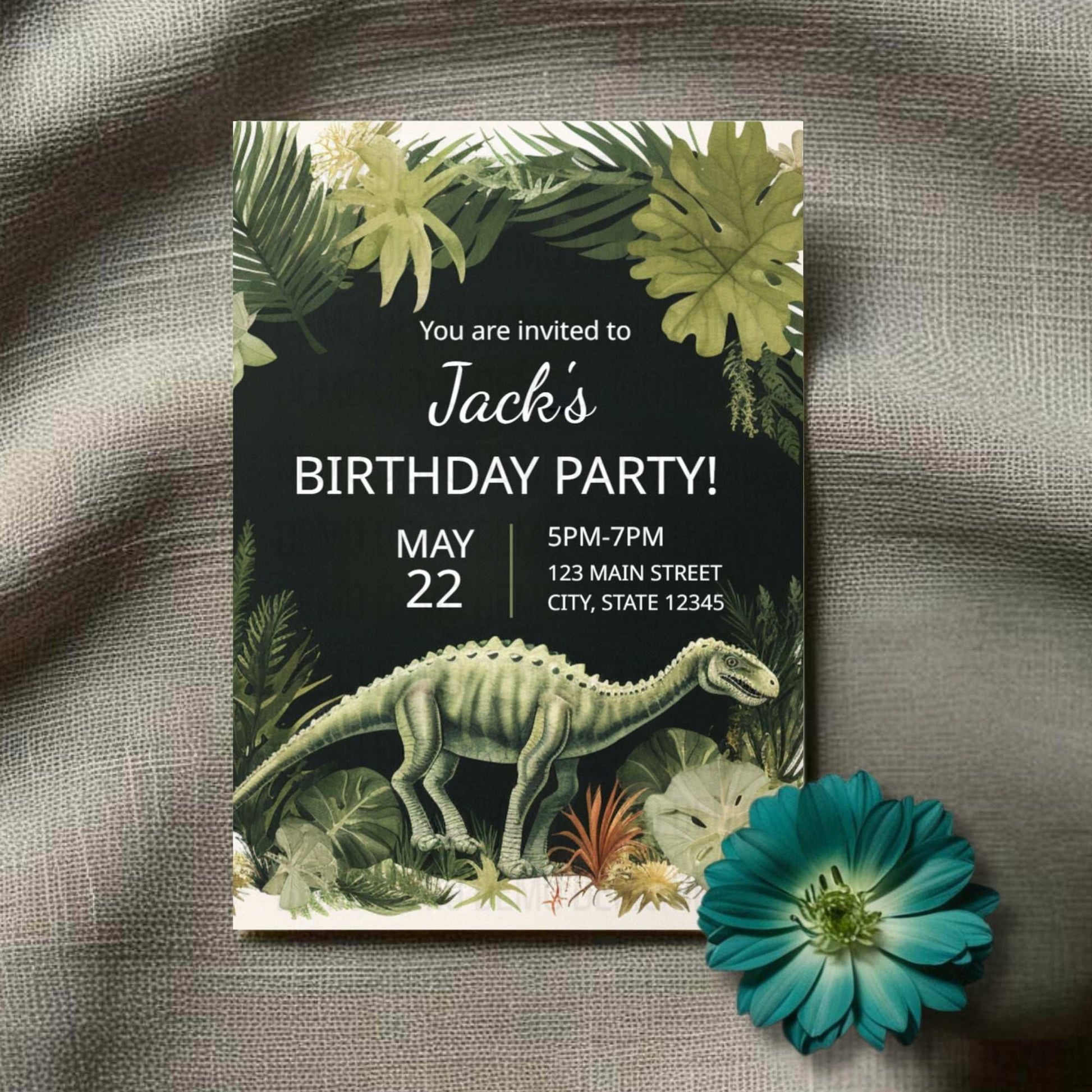 Birthday party invitation with dinosaur and tropical leaves design on a textured surface with a flower.
