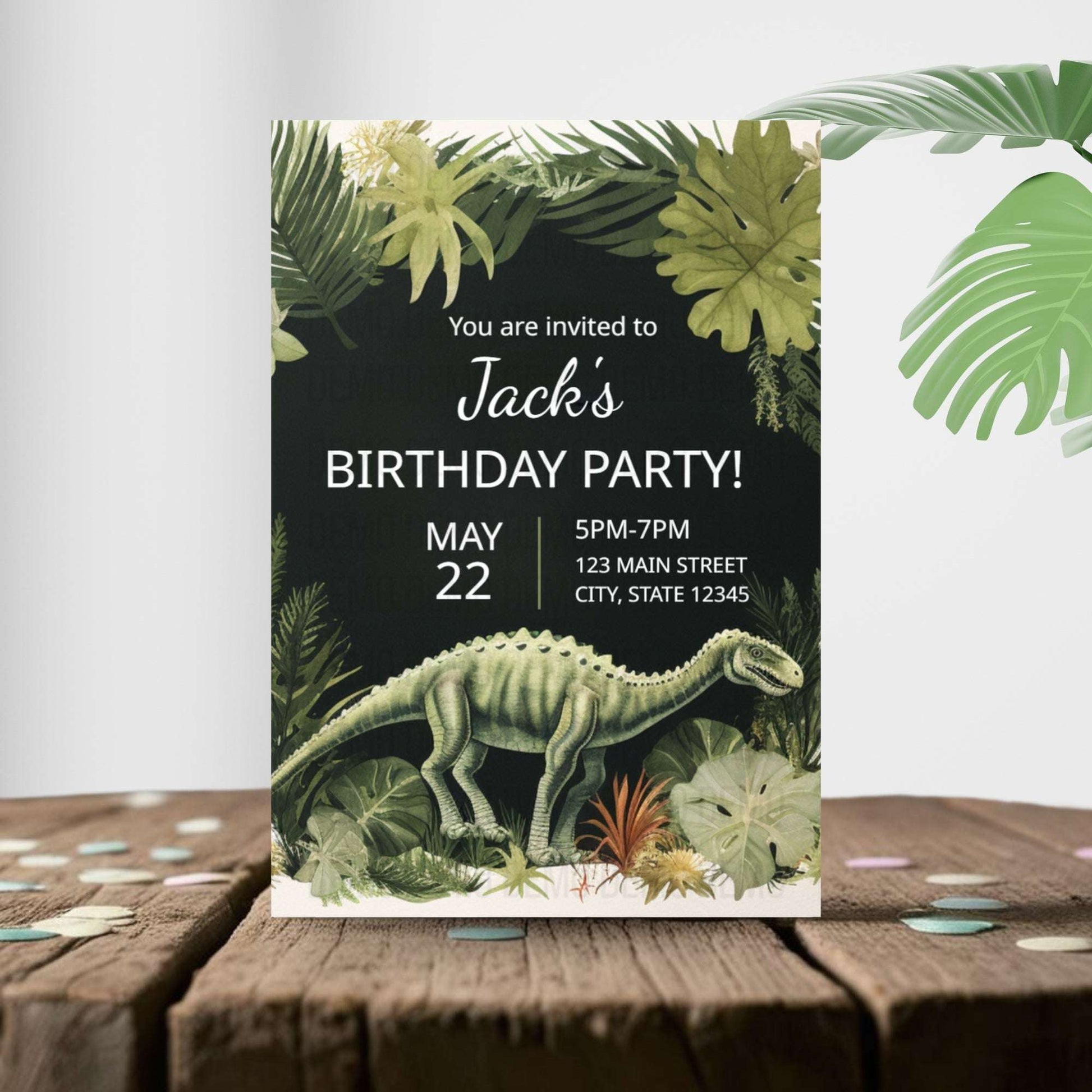 Birthday party invitation with dinosaur and tropical plants on a wooden surface