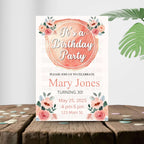 Birthday party invitation with floral design on a wooden surface