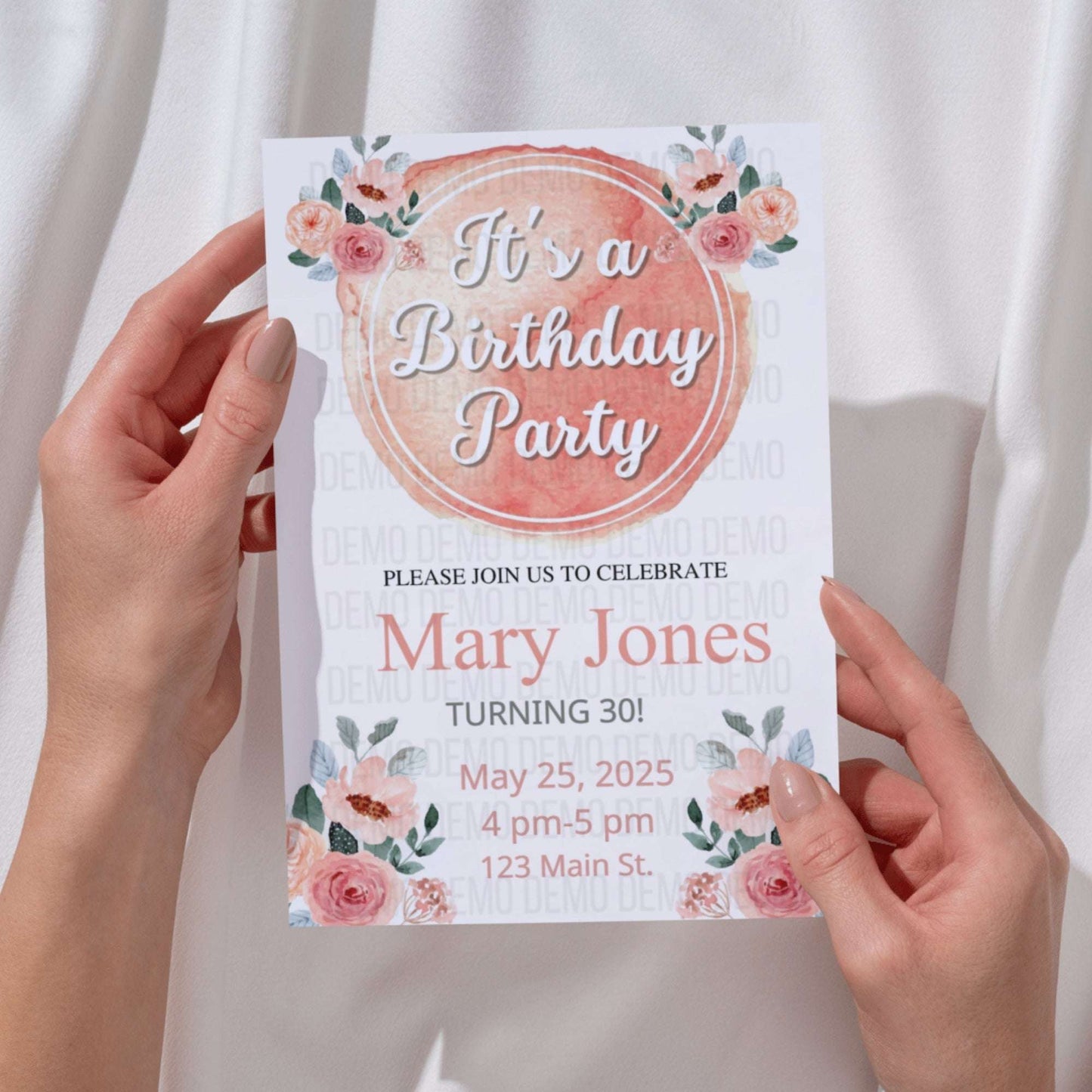 Birthday party invitation held by hands with floral design