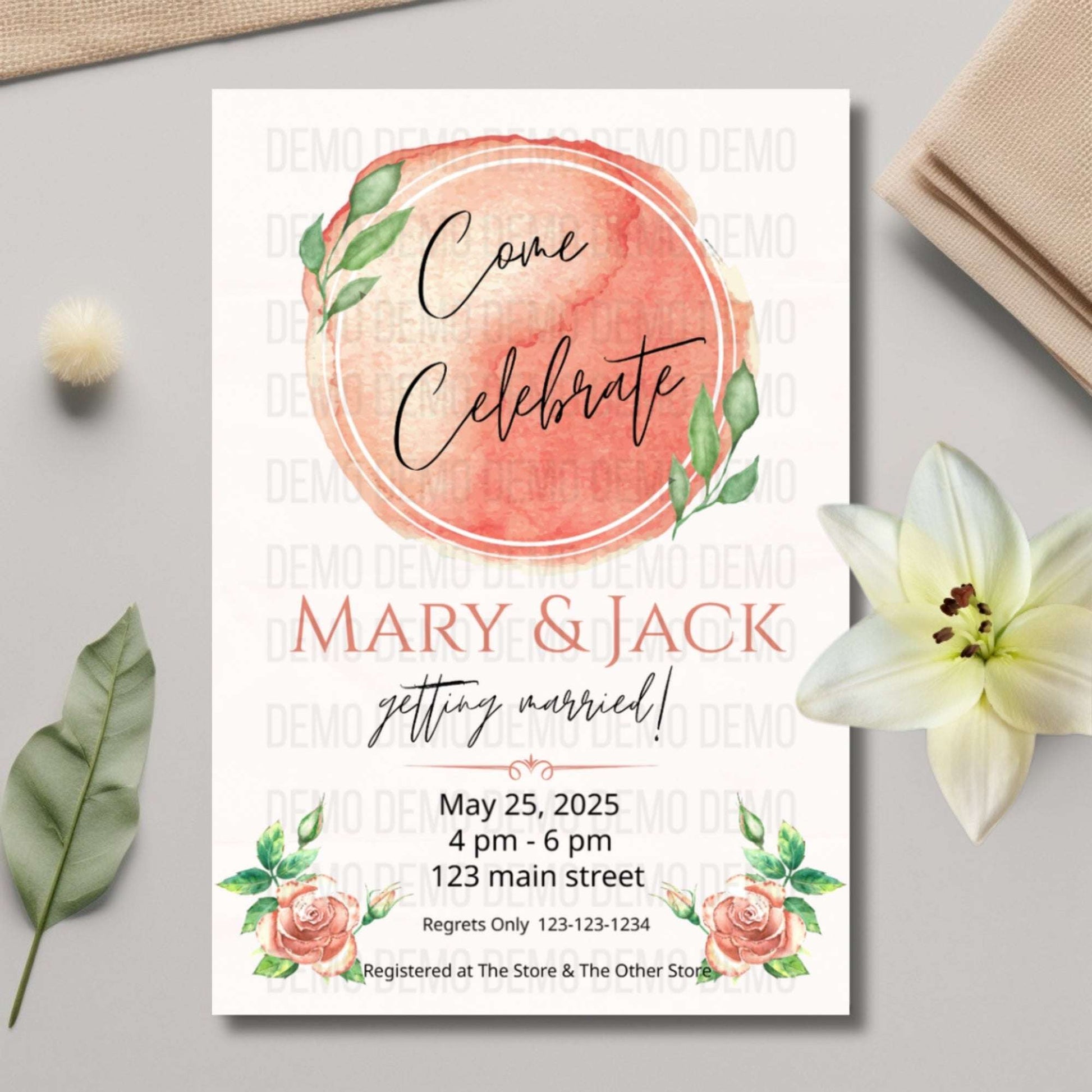 Wedding invitation card with floral design on a gray surface with flowers and leaves.