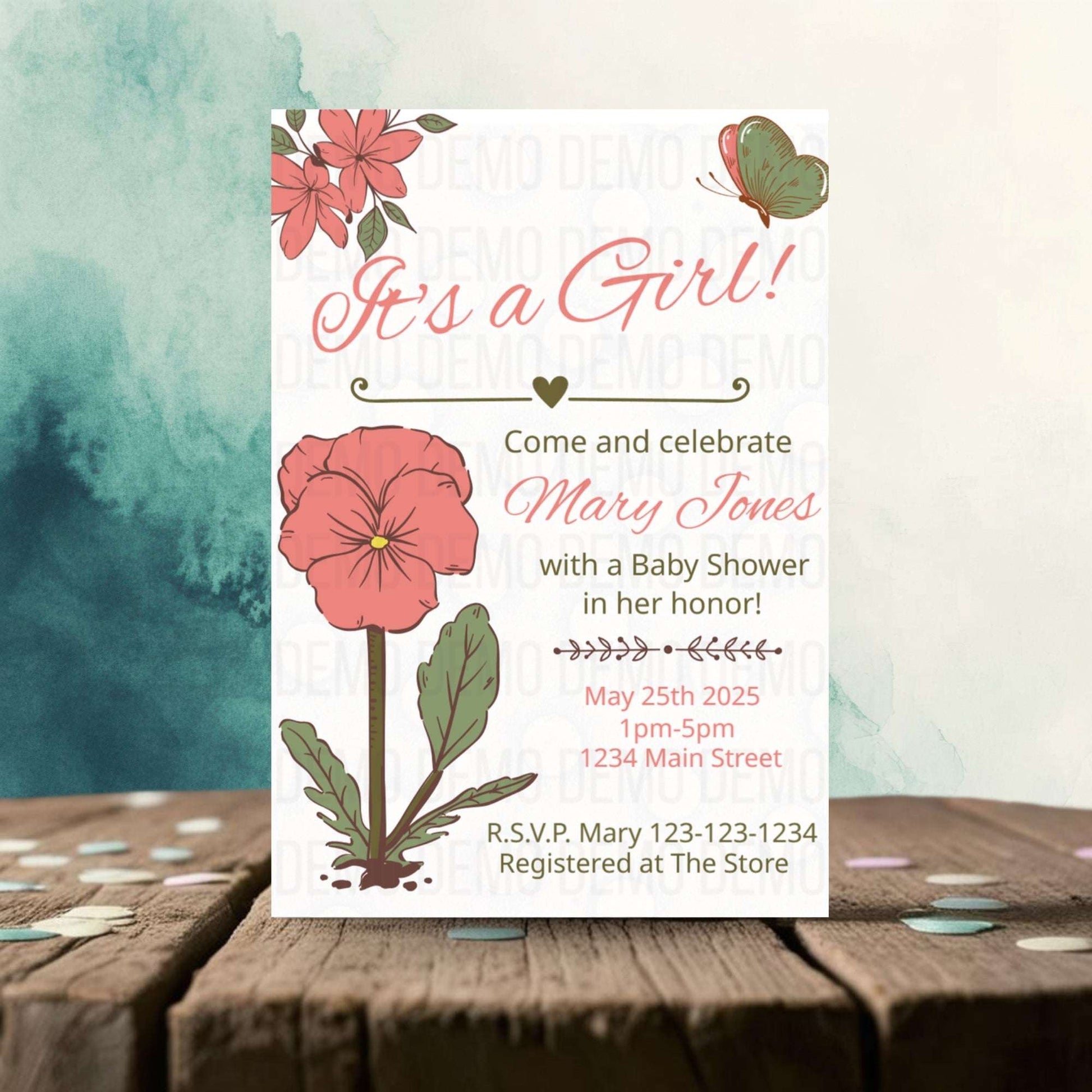 Baby shower invitation with floral design on a wooden surface