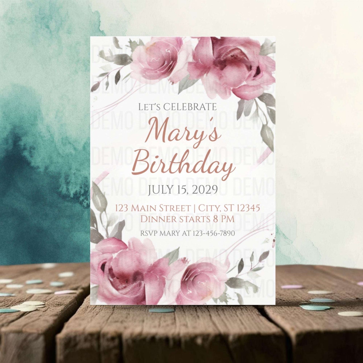 Birthday invitation card with pink flowers on a wooden surface
