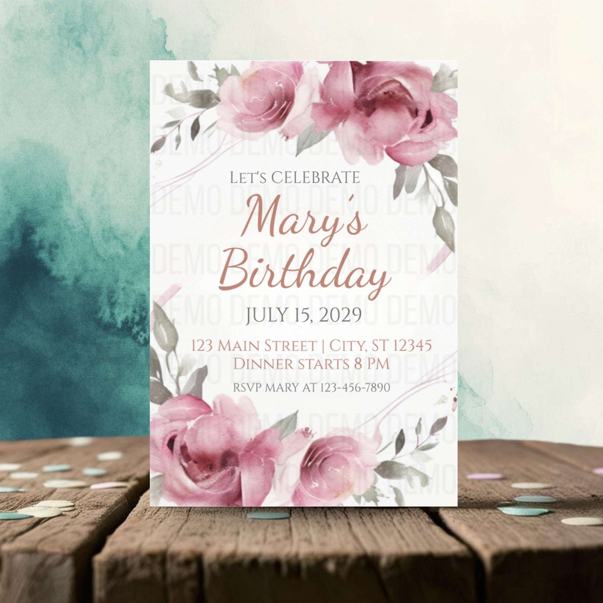 Birthday invitation card with pink flowers on a wooden surface