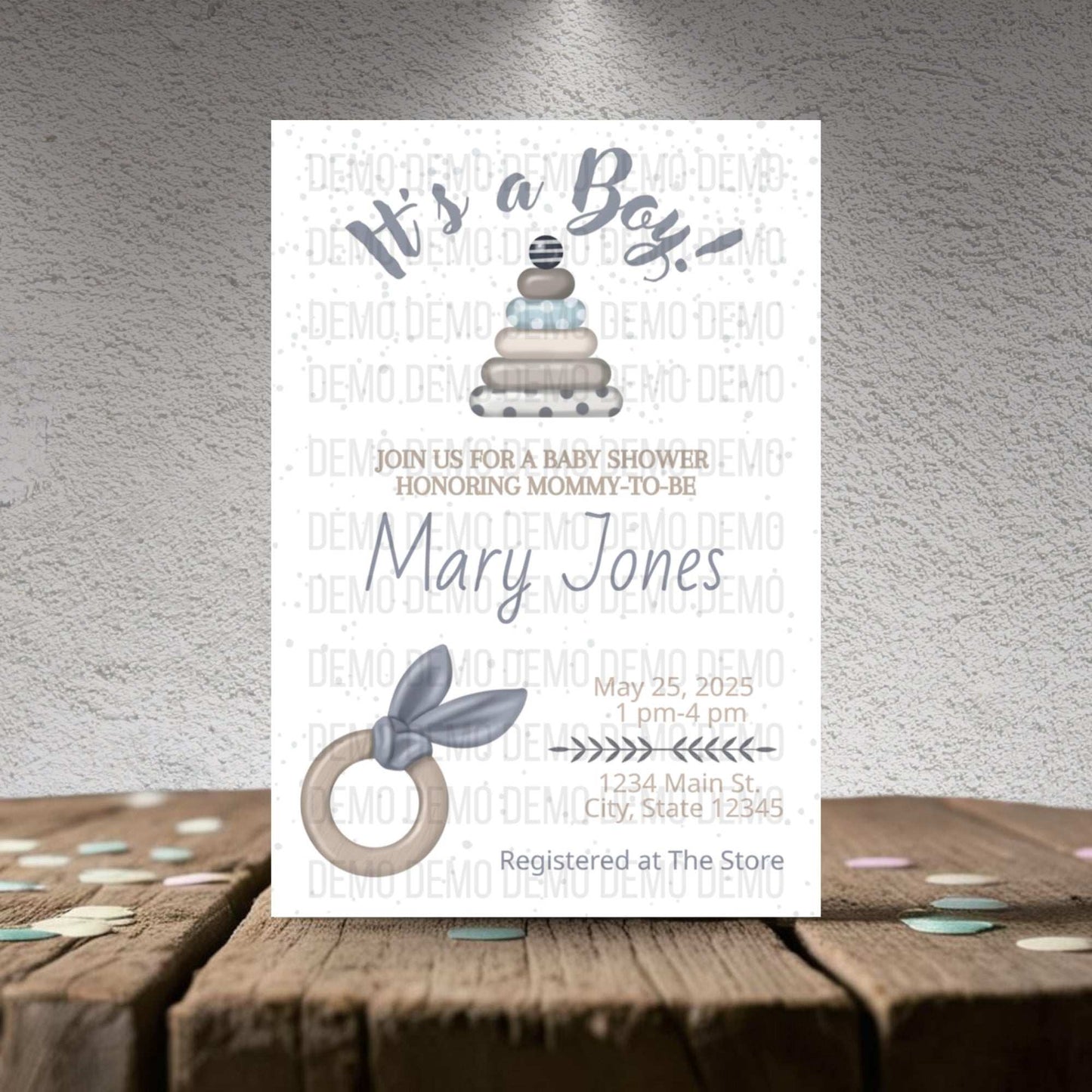 Baby shower invitation for a boy with cake and baby bootie design on a textured surface.