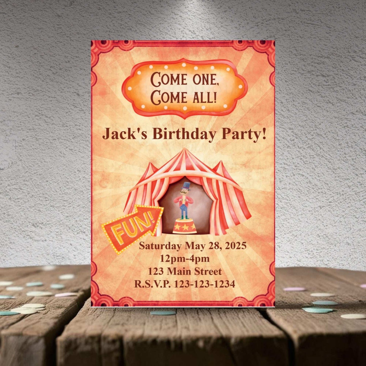 Birthday party invitation with a circus theme on a wooden surface.