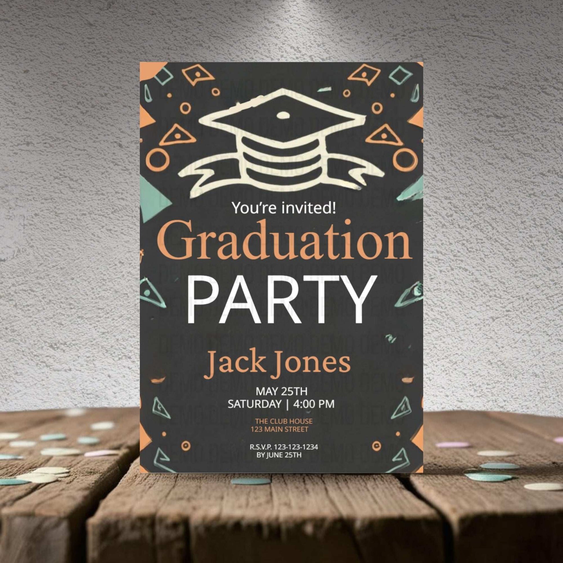 Graduation party invitation card on a wooden surface with a gray textured background