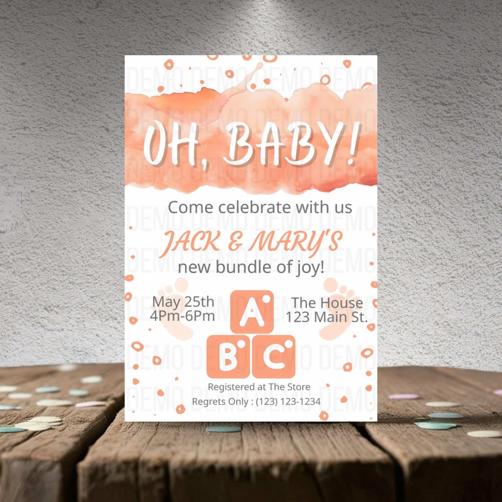 Baby shower invitation card with watercolor design on a wooden surface