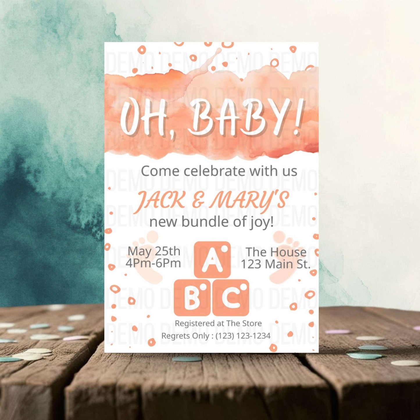 Baby shower invitation with watercolor design on a wooden surface