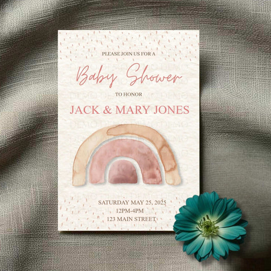 A personalized baby shower invitation with a boho aesthetic, featuring a rainbow illustration and cursive text on a speckled background. A blue flower is also present in the bottom right corner.
