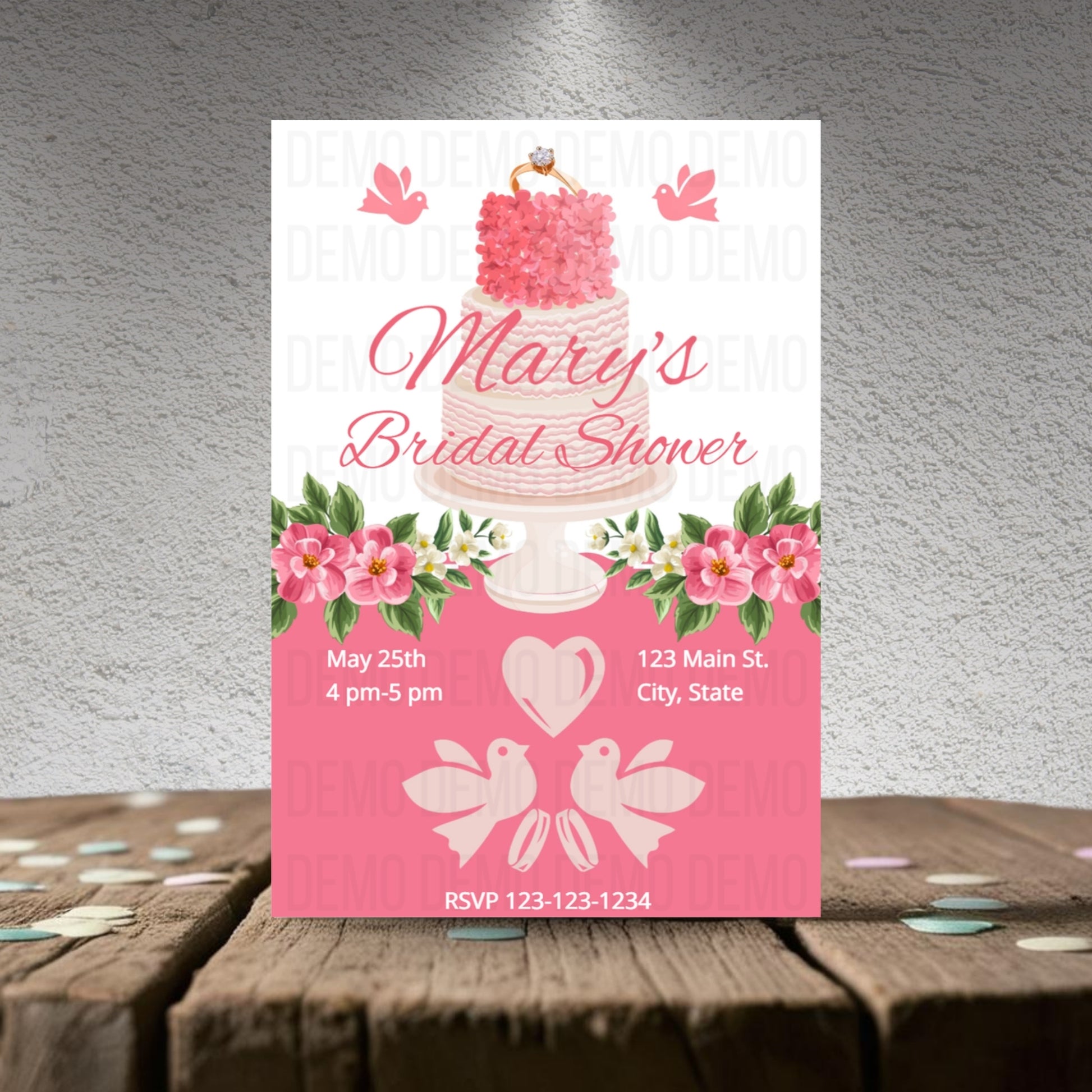 Bridal shower invitation with pink cake design on a textured surface