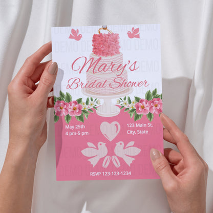 Bridal shower invitation with cake and floral design held by hands against a white background