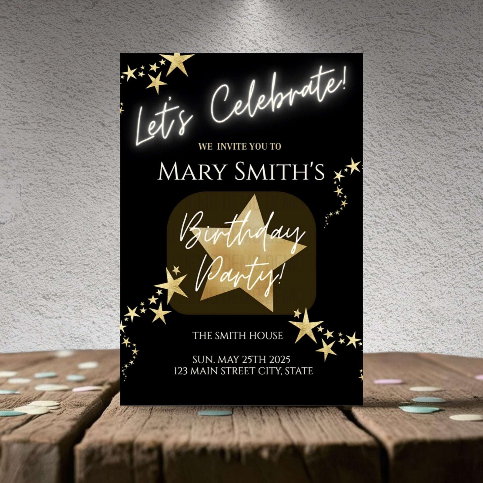 Birthday party invitation card with gold star design on a wooden surface.