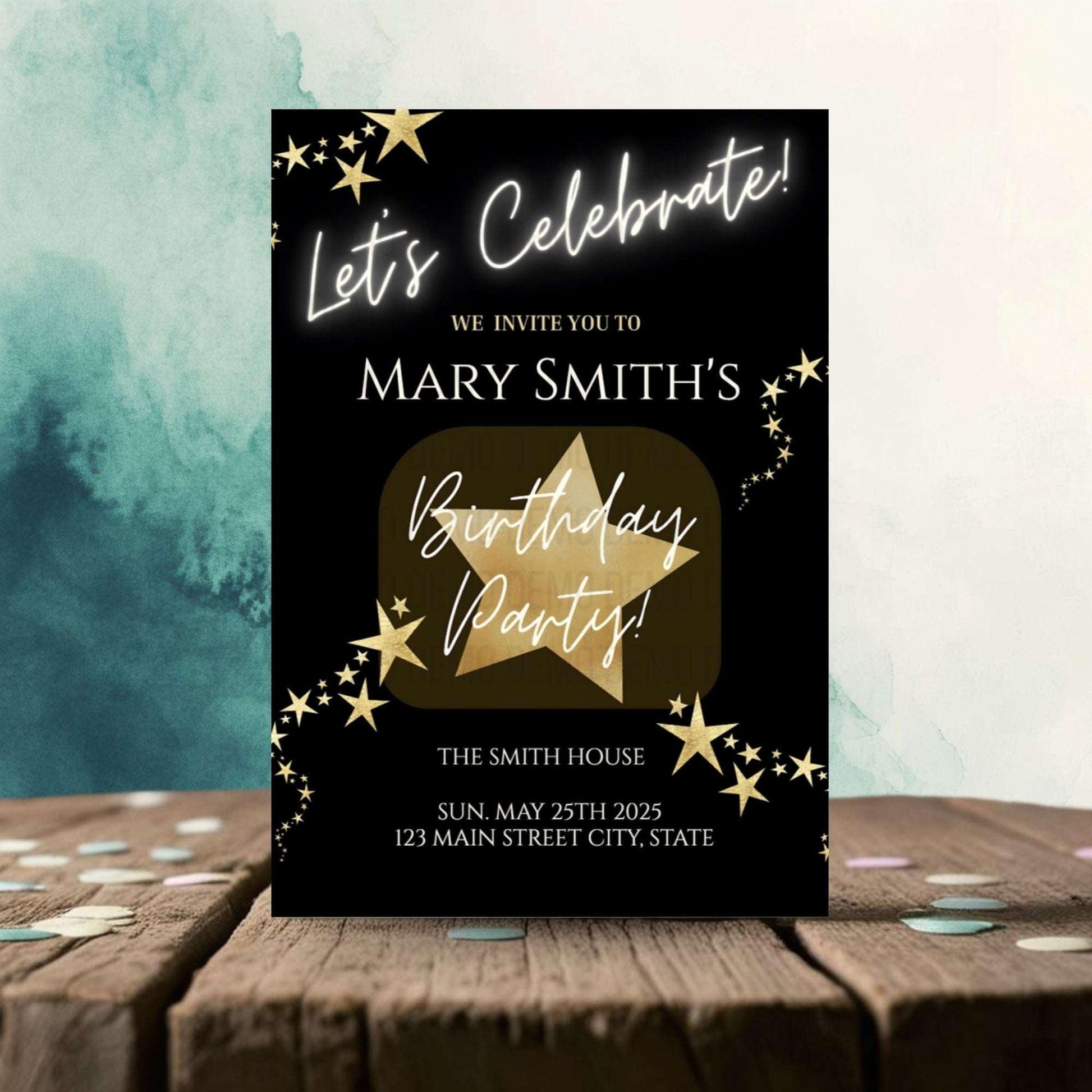 Birthday party invitation card with gold star design on a black background, placed on a wooden surface with confetti.