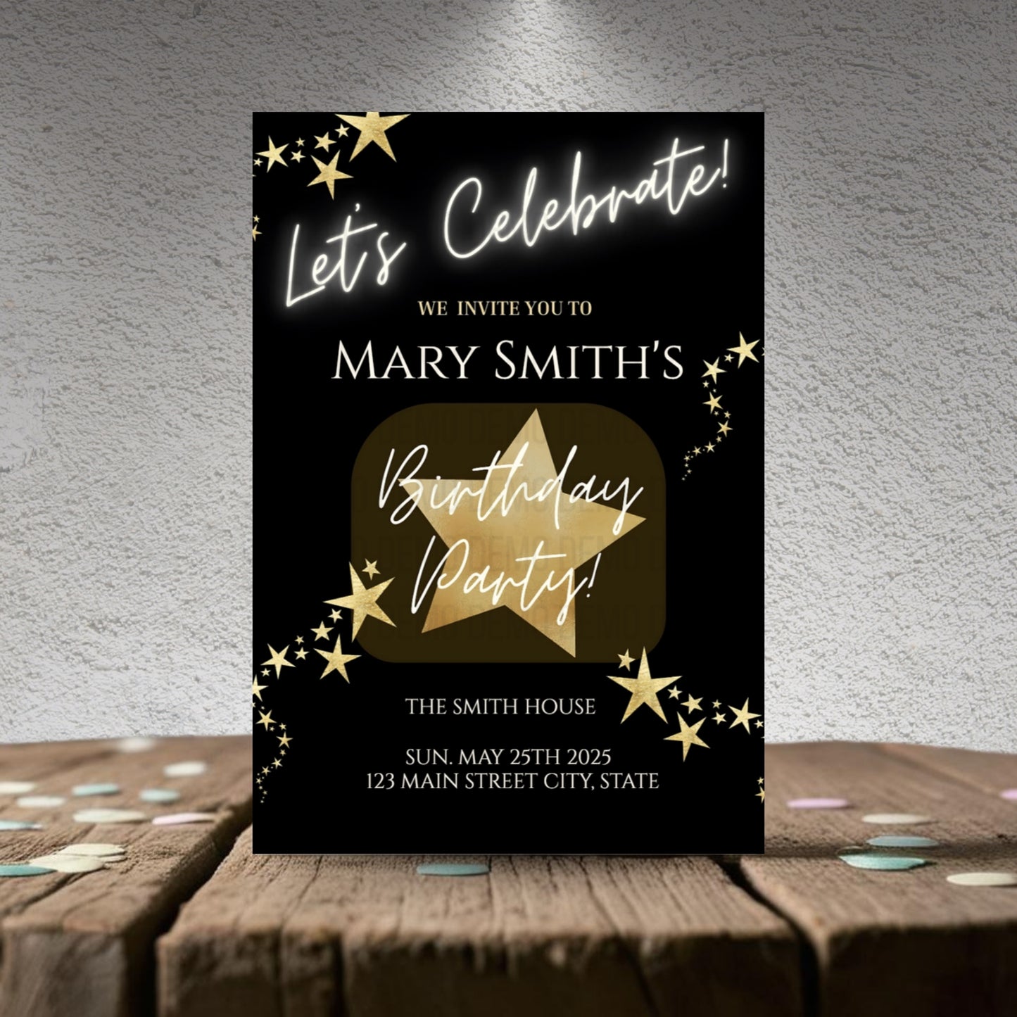 Birthday party invitation card with gold star design on a wooden surface.