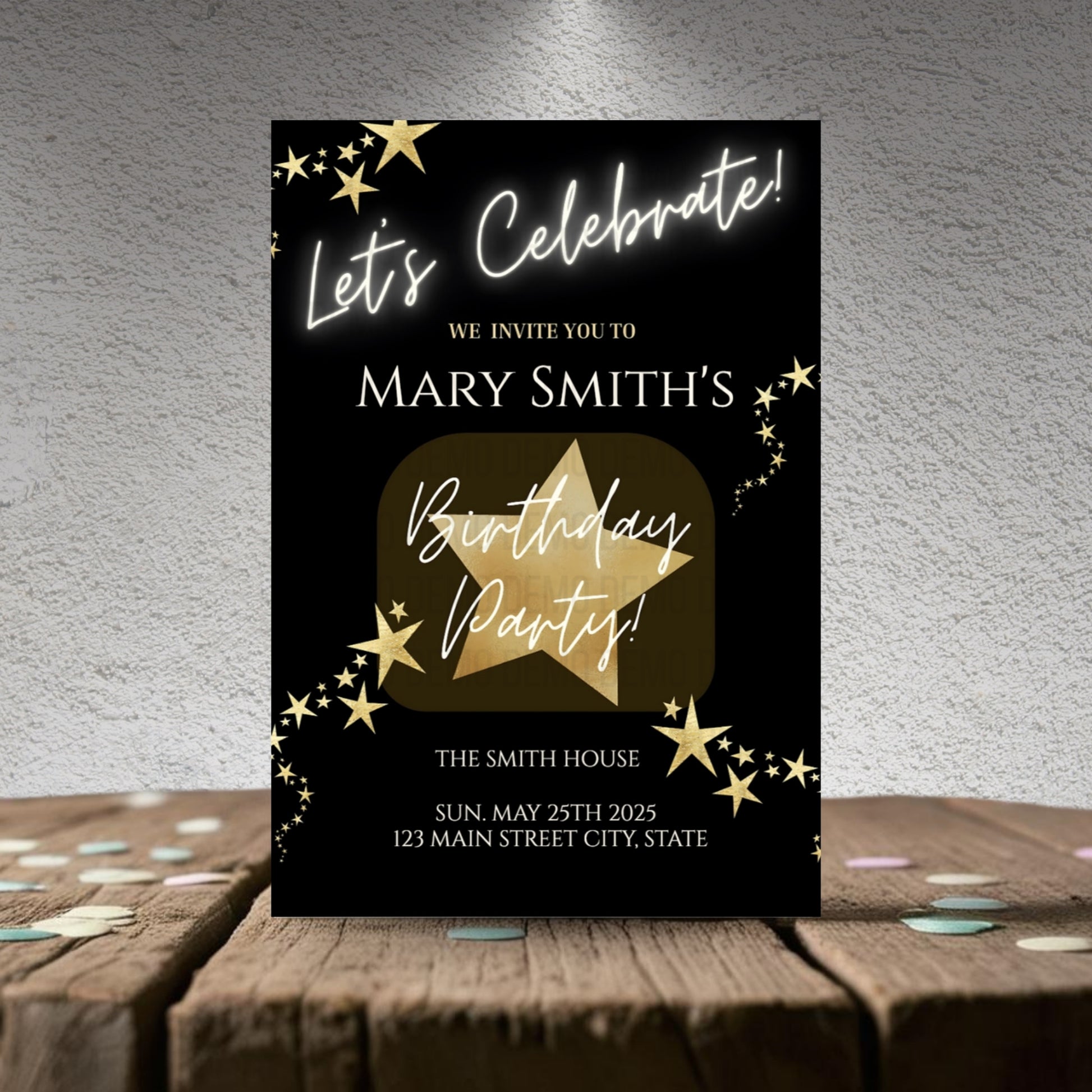 Birthday party invitation card with gold star design on a wooden surface.