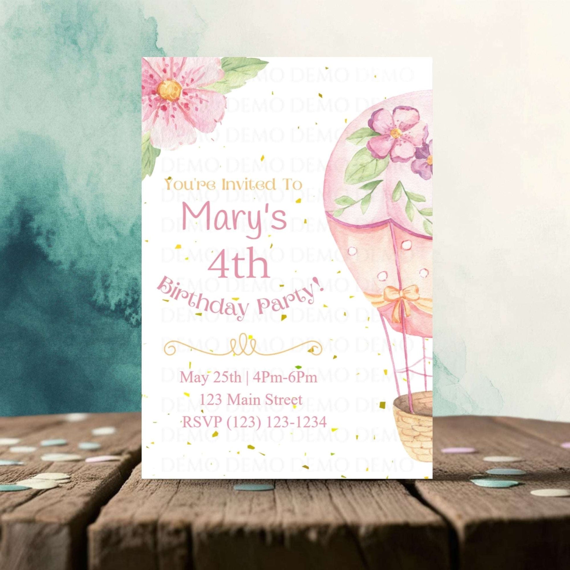 Birthday party invitation with pink balloons and flowers on a wooden surface