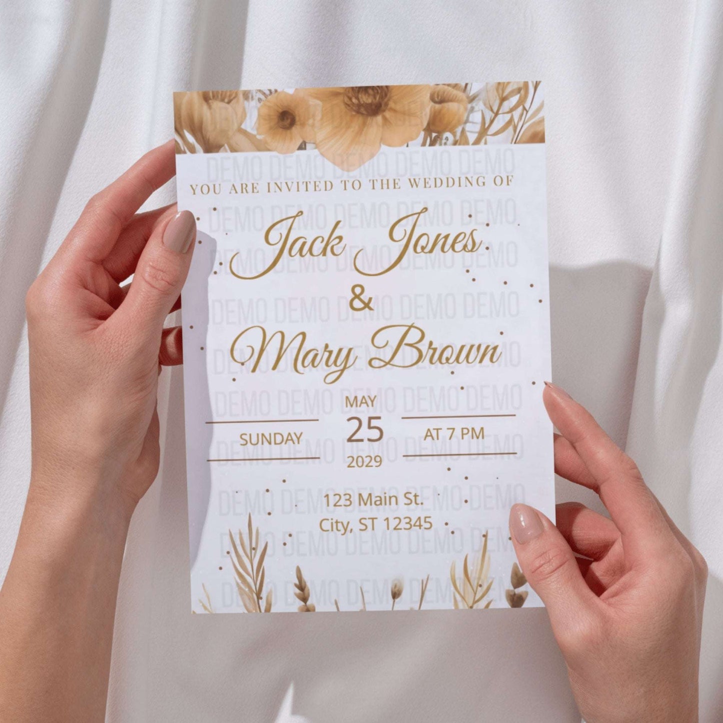 Wedding invitation card held by hands with floral design