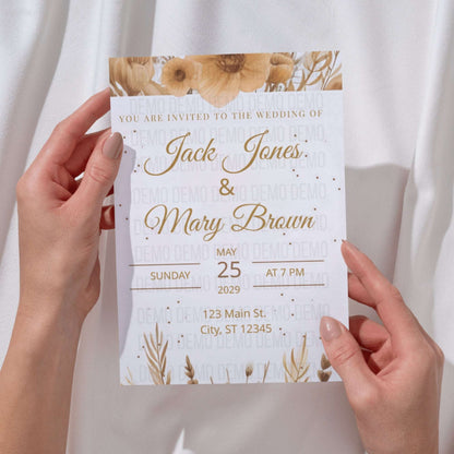 Wedding invitation card held by hands with floral design