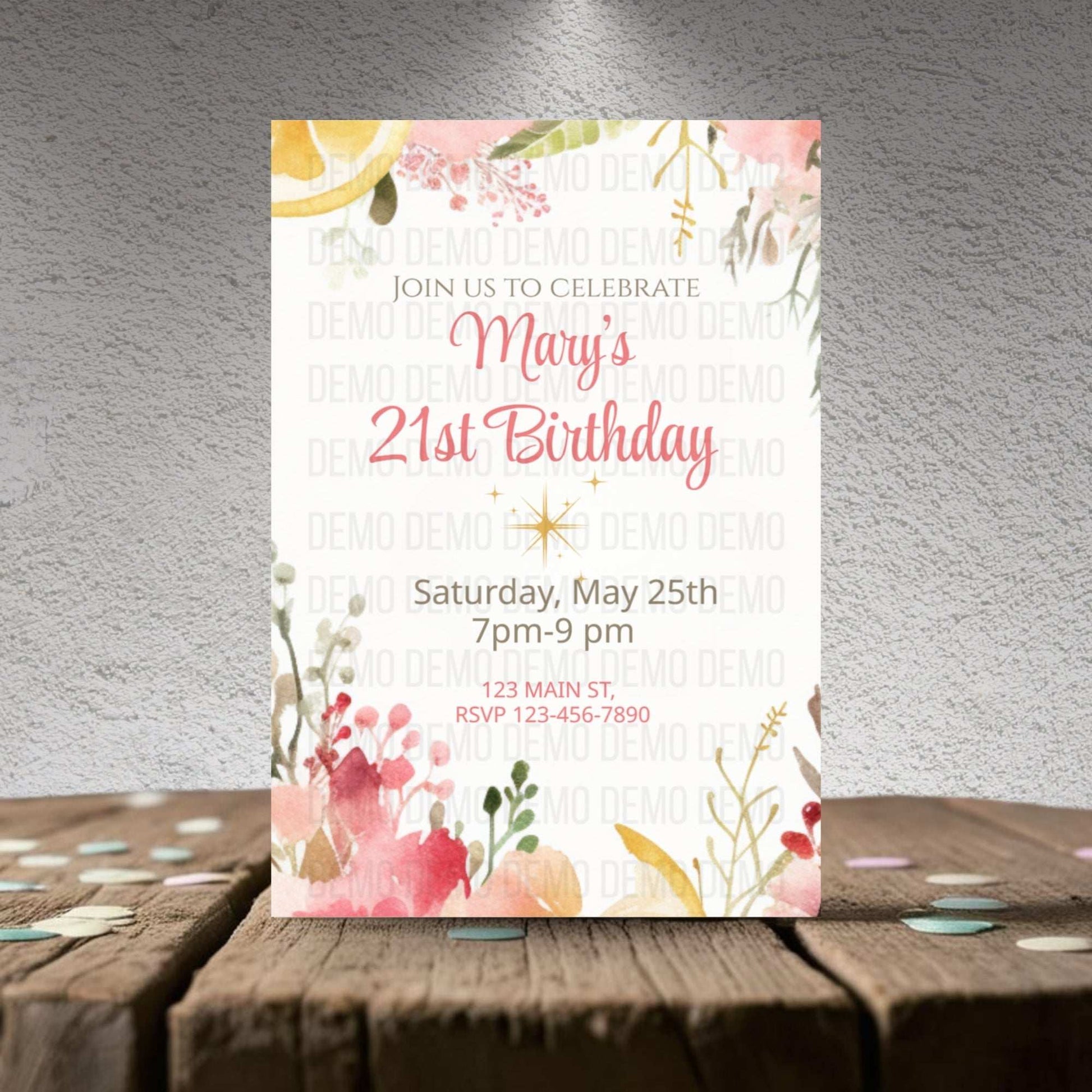 Invitation card for Mary's 21st birthday on a wooden surface with a textured gray wall background.
