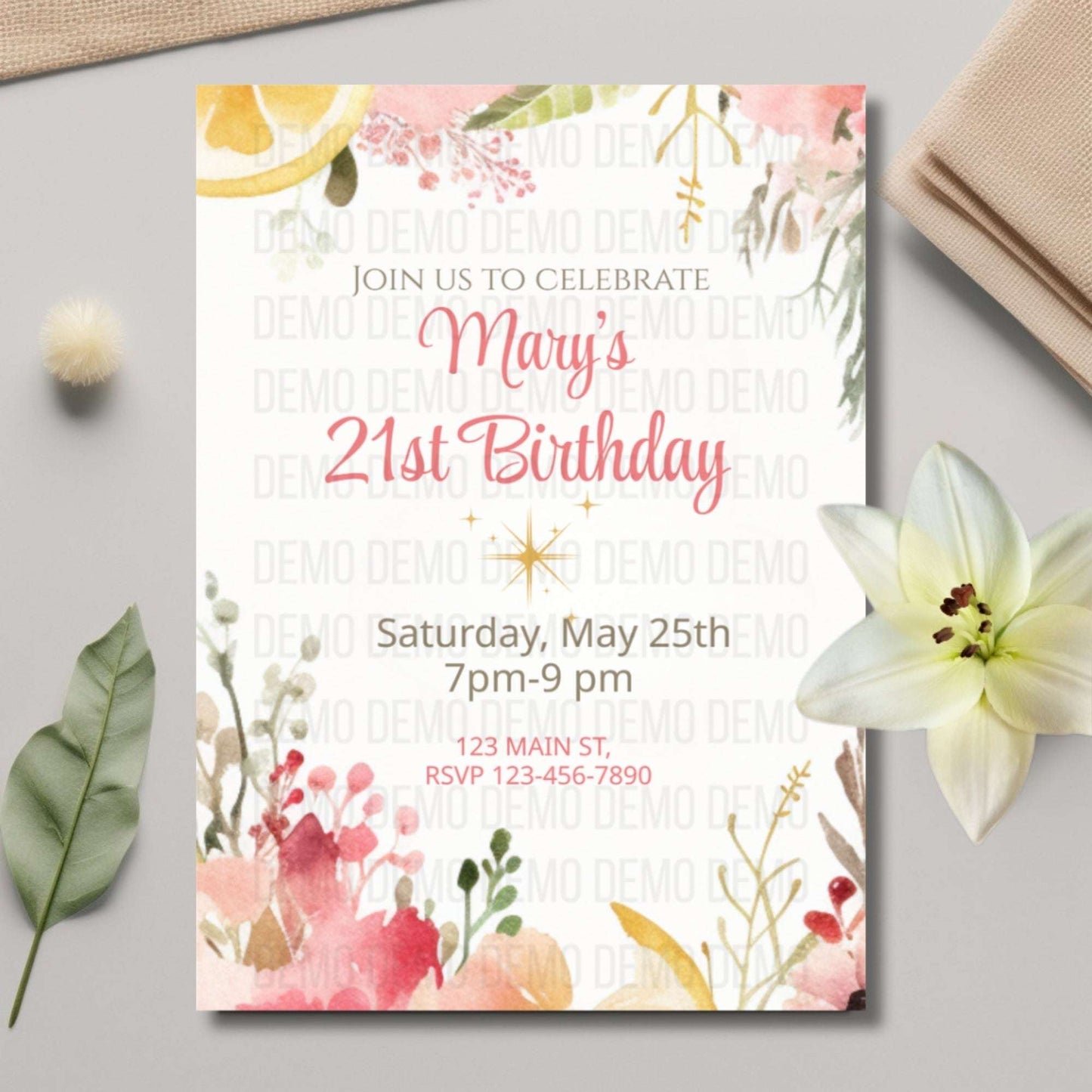 Floral birthday invitation card on a light gray surface with decorative elements.