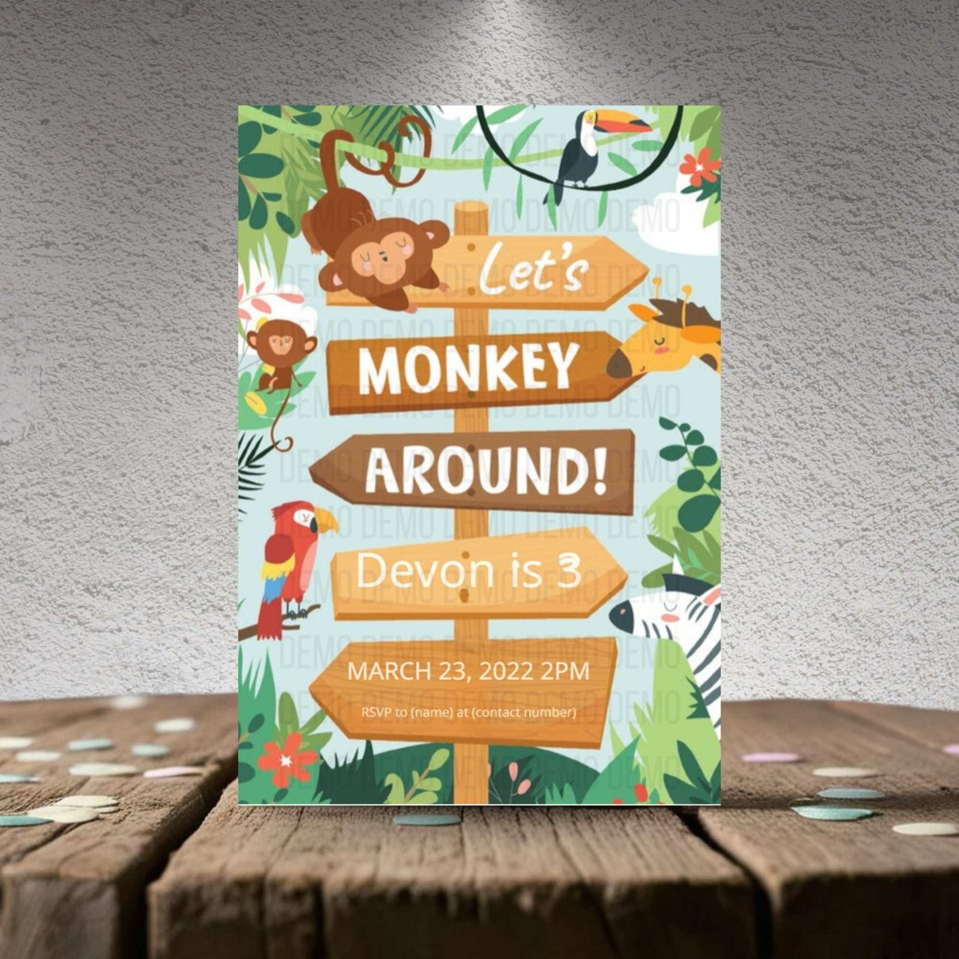 Children's birthday party invitation with monkey and jungle theme on a wooden surface.