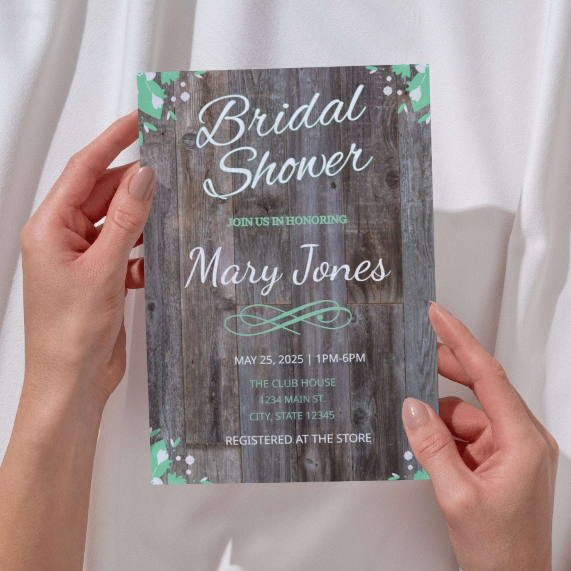 Bridal shower invitation with wooden texture held by hands against a white background