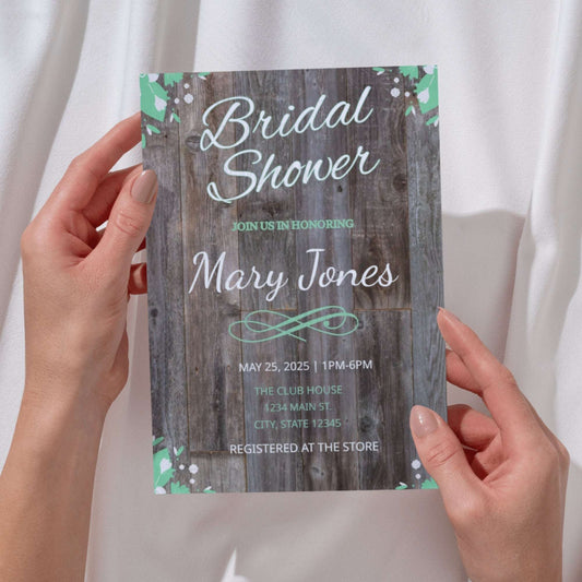 Bridal shower invitation with wooden texture held by hands against a white background
